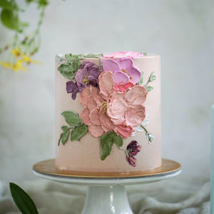 
                  
                    Load image into Gallery viewer, A light pink buttercream cake with pink and purple palette knife buttercream flowers.
                  
                