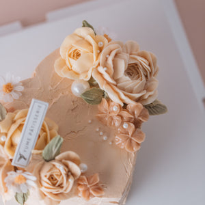 
                  
                    Load image into Gallery viewer, A light peachy pink heart shaped cake with light pink buttercream flowers and sugar pearls.
                  
                