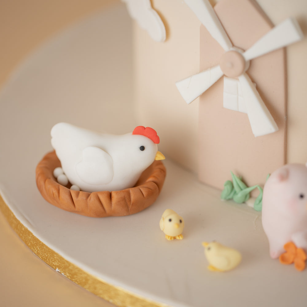 
                  
                    Load image into Gallery viewer, Close up on the fondant chicken and chicks. The chicken is white and sitting in a brown nest, and the nest has tiny fondant eggs inside. There are two yellow chicks near the hen.
                  
                