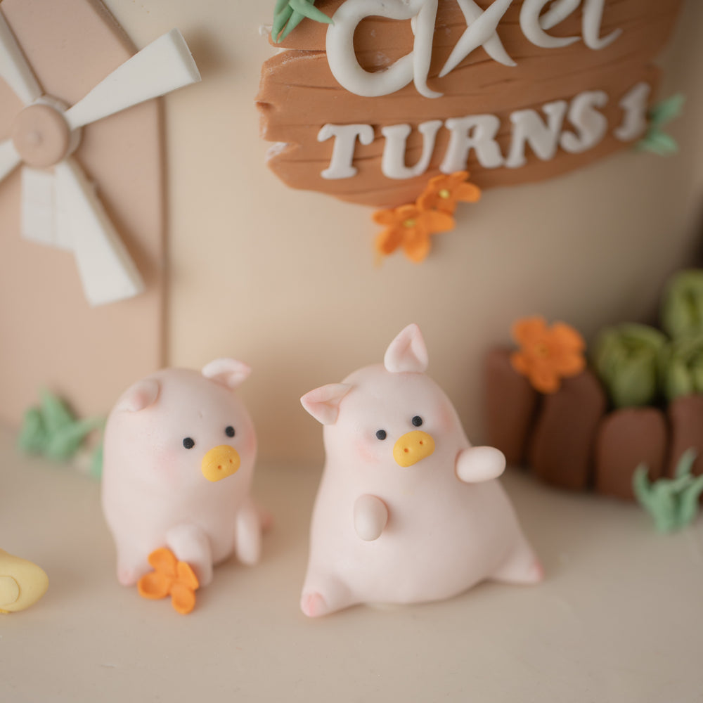
                  
                    Load image into Gallery viewer, A close up on the 3D fondant pigs. The pigs are light pink and sitting down. They are very cute.
                  
                