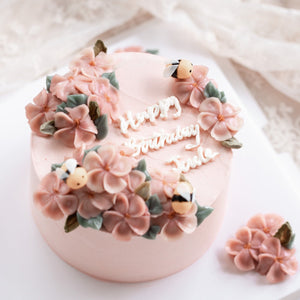 
                  
                    Load image into Gallery viewer, A light pink buttercream cake with pink buttercream flowers on top, decorated with little fondant bees. &amp;quot;Happy Birthday&amp;quot; is written in buttercream cursive in the middle of the cake.
                  
                