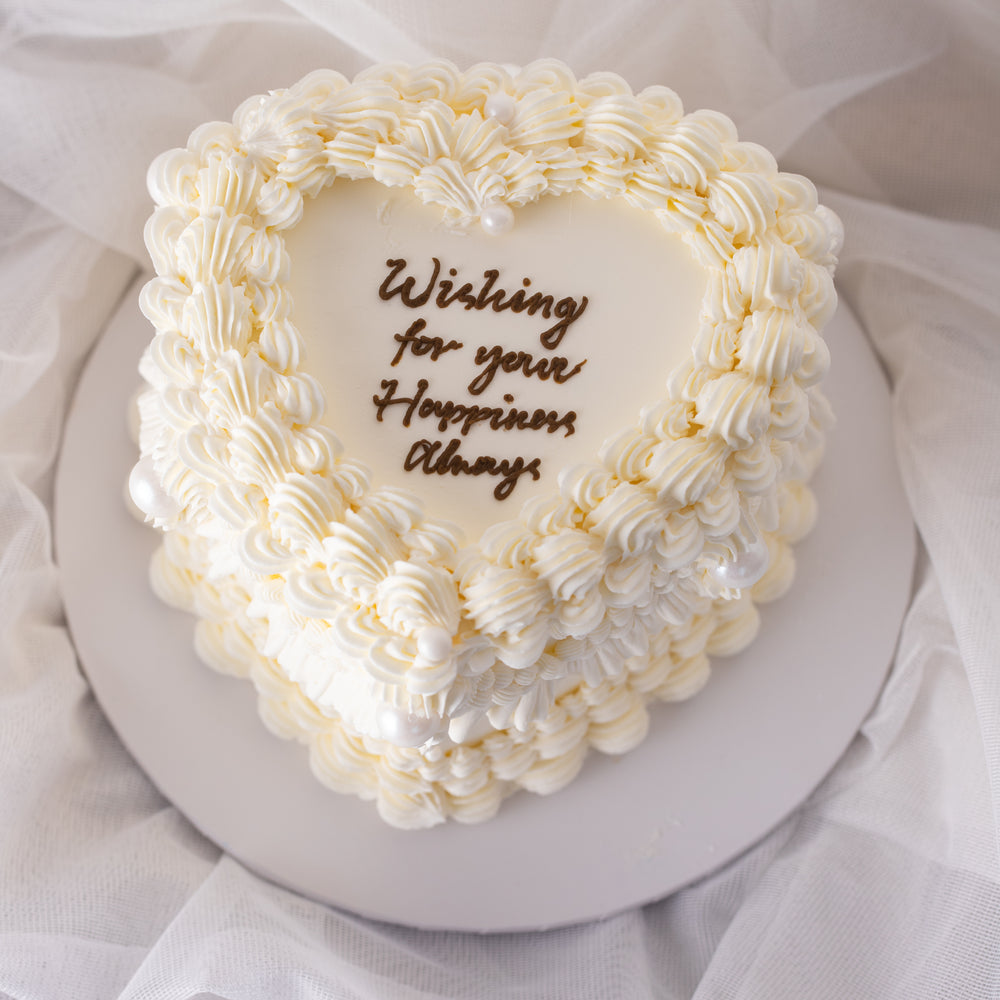
                  
                    Load image into Gallery viewer, A beautiful white buttercream heart shaped cake with vintage baroque styled buttercream piping. The buttercream is white, giving the cake an elegant, princess-y feel. The cake is extremely beautiful.
                  
                