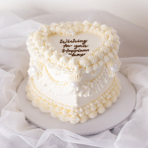 
                  
                    Load image into Gallery viewer, A beautiful white buttercream heart shaped cake with vintage baroque styled buttercream piping. The buttercream is white, giving the cake an elegant, princess-y feel. The cake is extremely beautiful.
                  
                